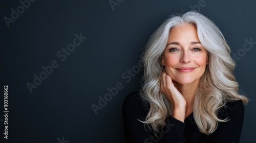 A close-up image of a smiling woman with silver hair, posed against a dark background, capturing a sense of warmth and inner peace in her expression.