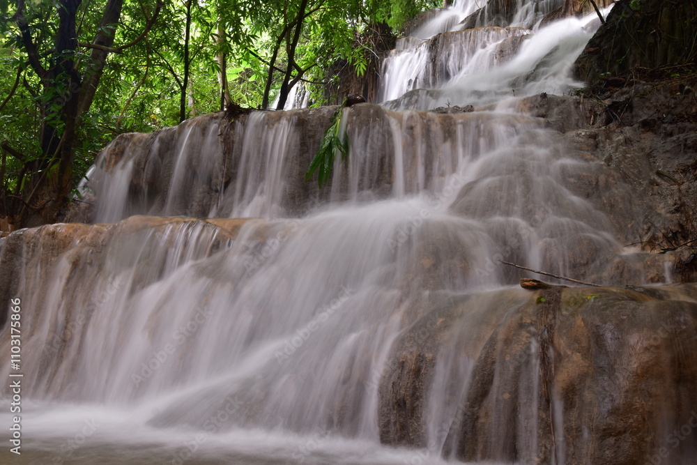 Fototapeta premium Travel to waterfalls during the rainy season, The tiers of the waterfall contrast beautifully with the sky, Nature itself is the best physician