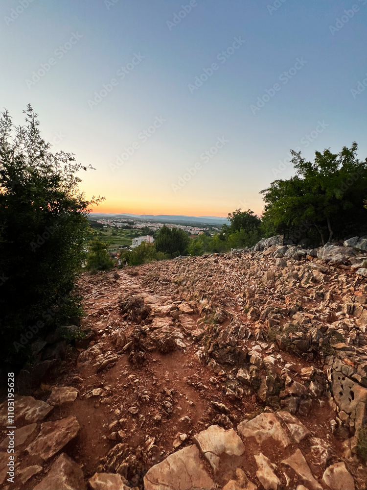 Fototapeta premium Beautiful sunset over rocky landscape and distant horizon view. Apparition Hill, Medjugorje, Bosnia and Herzegovina.