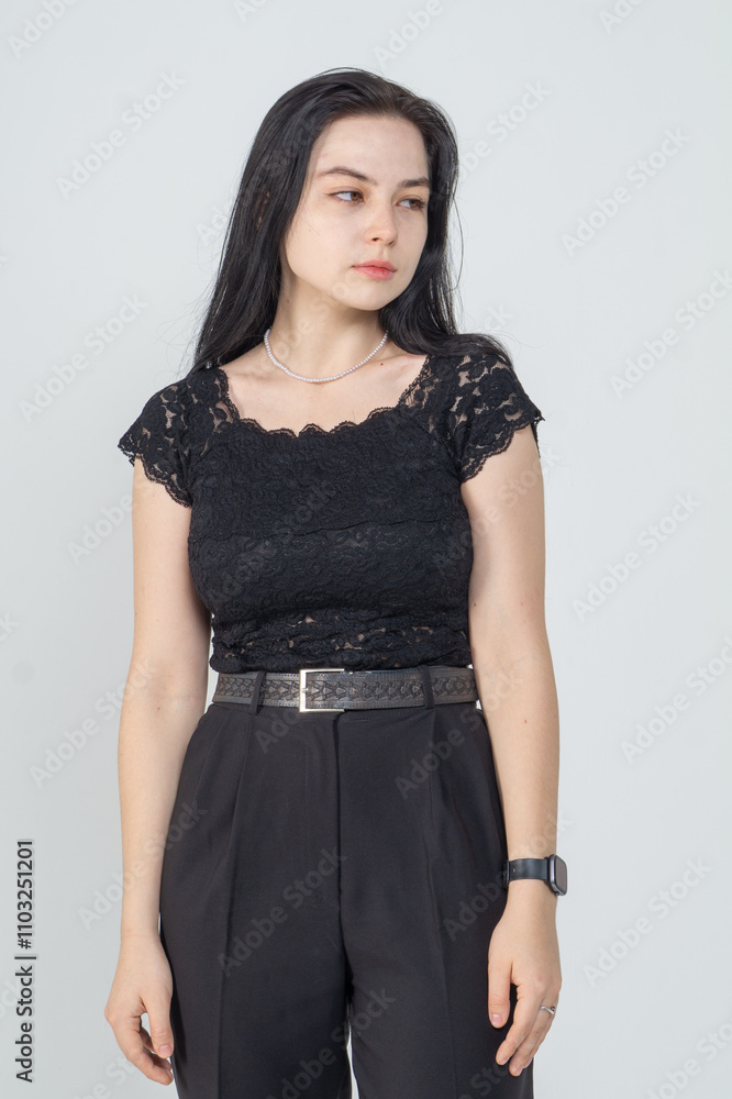 Cute young brunette girl standing on a white background. Copy space