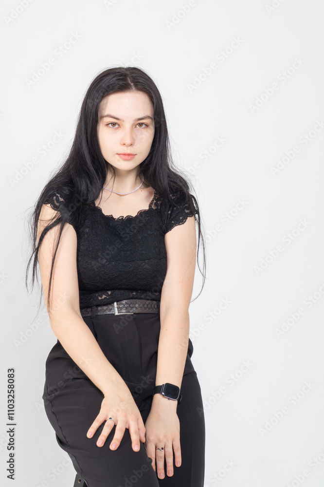 Cute young brunette girl sitting on a white background. Copy space Cute young brunette girl sitting on a white background. Copy space