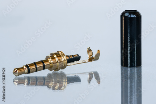 Macro shot of 4-pin disassembled gold plated mini jack connector for replacement isolated on white background with reflection photo