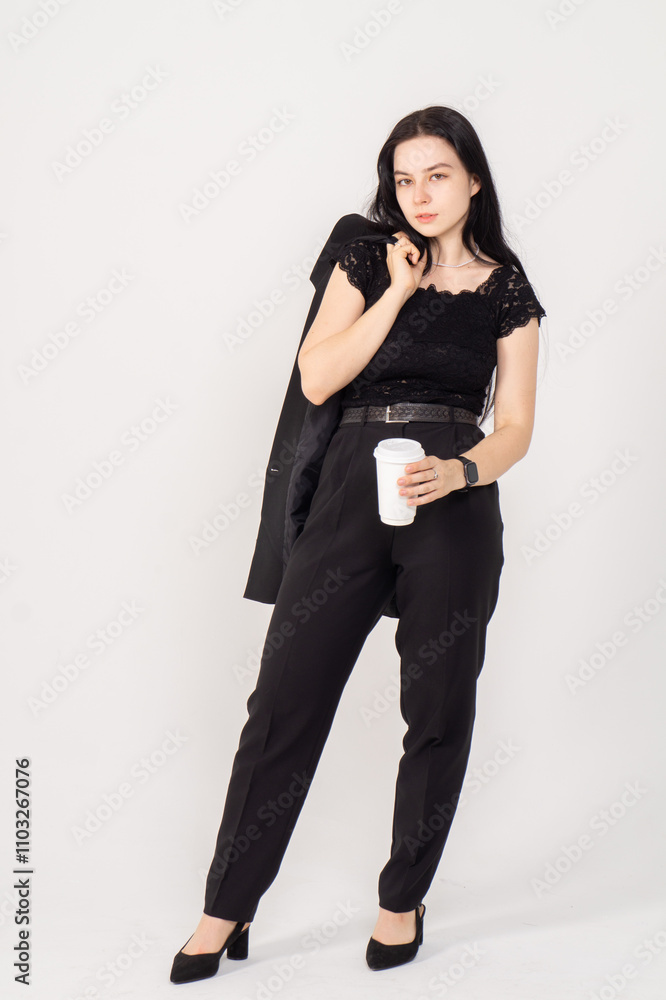 Cute young brunette with a coffee cup on a white background. Copy space