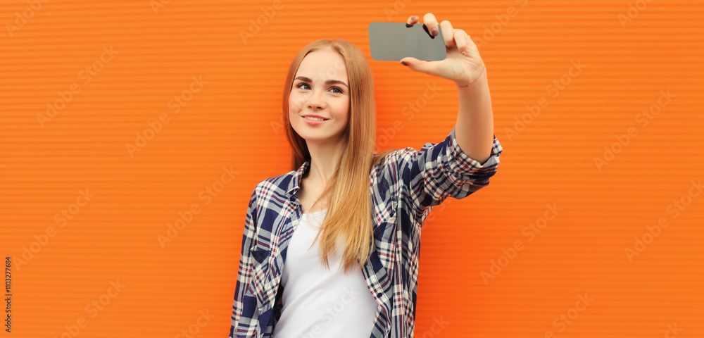 Happy cheerful smiling young woman taking selfie with phone, joyful girl holding smartphone in city Happy cheerful smiling young woman taking selfie with phone, joyful girl holding smartphone in city