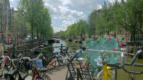 Bicycles parked on the railing of a bridge over a canal. Amsterdam Holland.