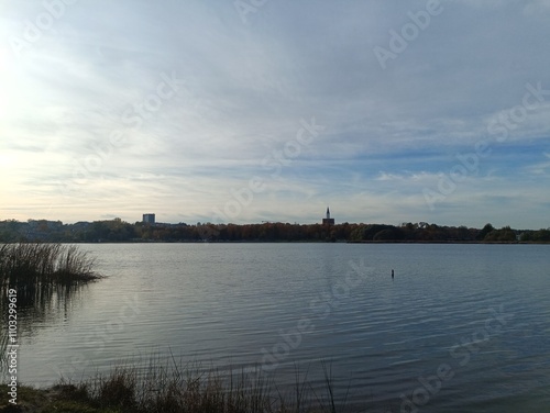 Talsa lake during sunny day. Lake with small waves. Sunny day with white and gray clouds in sky. Nature. Talsos ezeras.