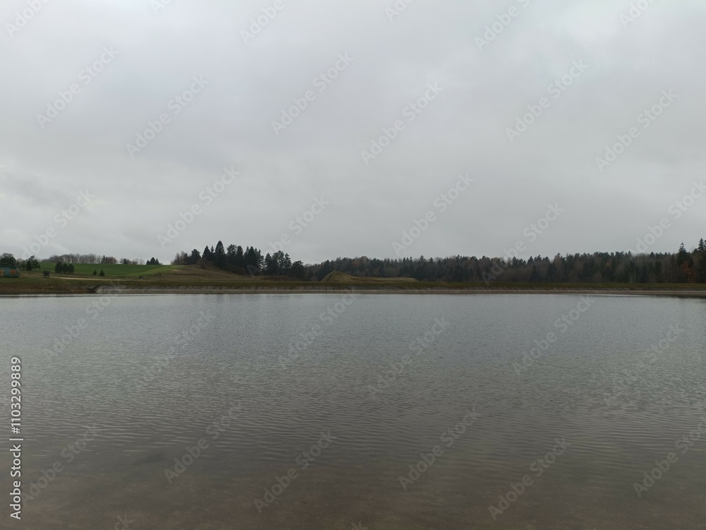 Bubiai lake during cloudy day. Lake with small waves. Cloudy day with white and gray clouds in sky. Nature. Bubiu ezeras. Bubiai lake during cloudy day. Lake with small waves. Cloudy day with white and gray clouds in sky. Nature. Bubiu ezeras.
