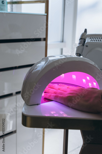 Manicure process. Drying nails in a device with ultraviolet lamps.