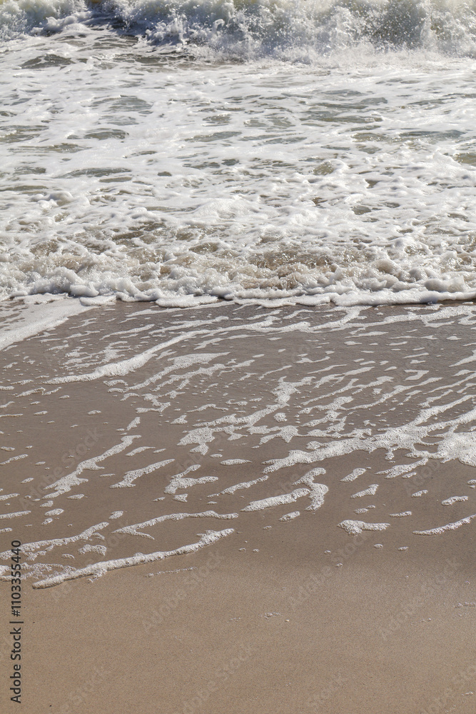 Close-up of delicate foam patterns left on the sandy shoreline as ocean waves recede, creating a serene and textured coastal scene Close-up of delicate foam patterns left on the sandy shoreline as ocean waves recede, creating a serene and textured coastal scene