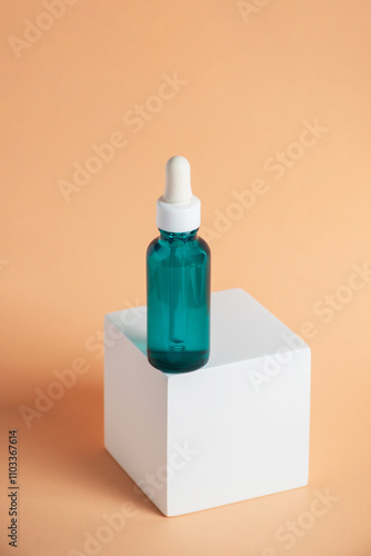 Blue glass cosmetic bottle, Skin care or sunscreen cosmetic with stylish props on cream background.