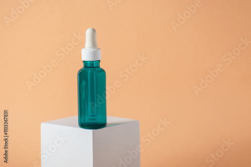 Blue glass cosmetic bottle, Skin care or sunscreen cosmetic with stylish props on cream background.