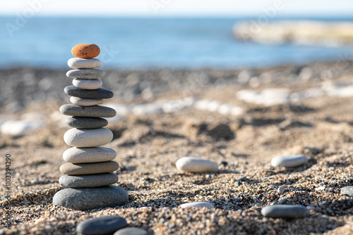 Pyramids of sea pebbles on the beach against the sea on a Sunny day