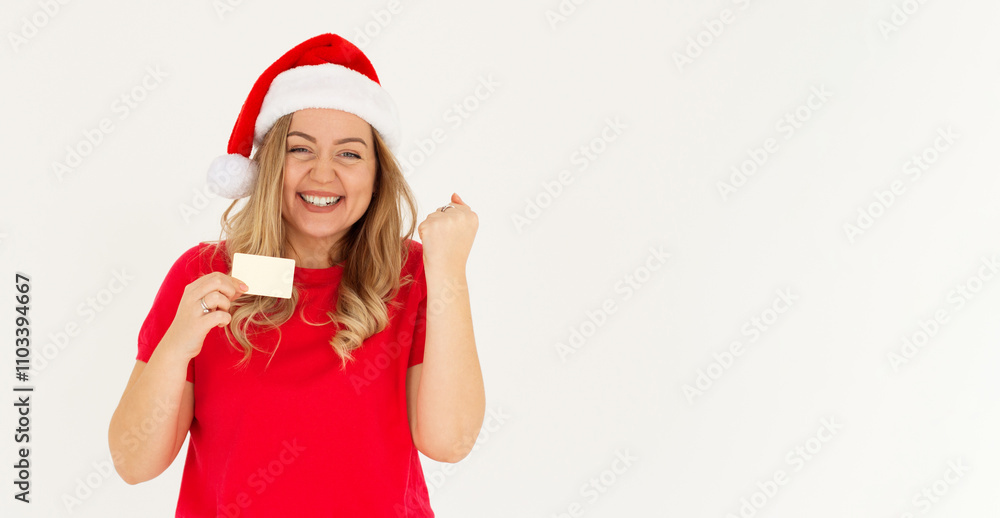 Excited happy positive cheerful smiling Beautiful woman wearing christmas hat hold credit card raise fist in victory Excited happy positive cheerful smiling Beautiful woman wearing christmas hat hold credit card raise fist in victory