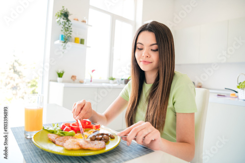 Young girl enjoying a nutritious meal in her bright and modern kitchen