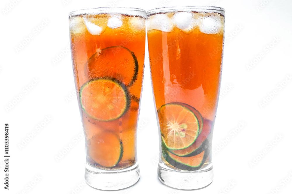 Close up Glass of iced tea with lemon, lime and ice cubes isolated on white background. Two glasses of sweet iced tea filled with lemon slices Close up Glass of iced tea with lemon, lime and ice cubes isolated on white background. Two glasses of sweet iced tea filled with lemon slices