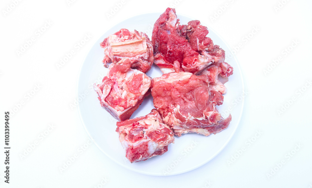 sliced bones and fresh raw beef on a white plate isolated on a white background. fresh spare ribs sliced bones and fresh raw beef on a white plate isolated on a white background. fresh spare ribs