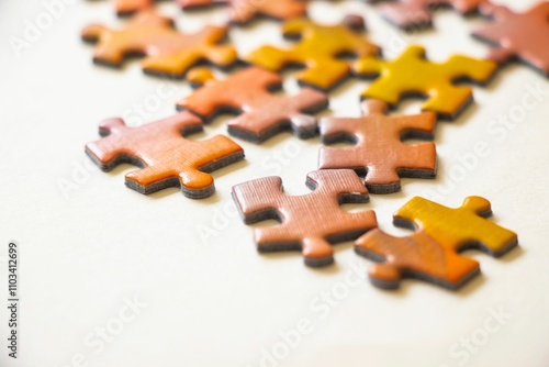 Closeup of scattered puzzle pieces on a white surface