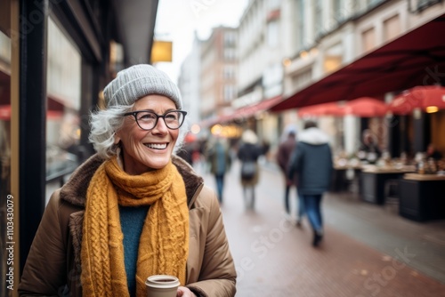 Portrait of smiling senior woman with cup of coffee in the city