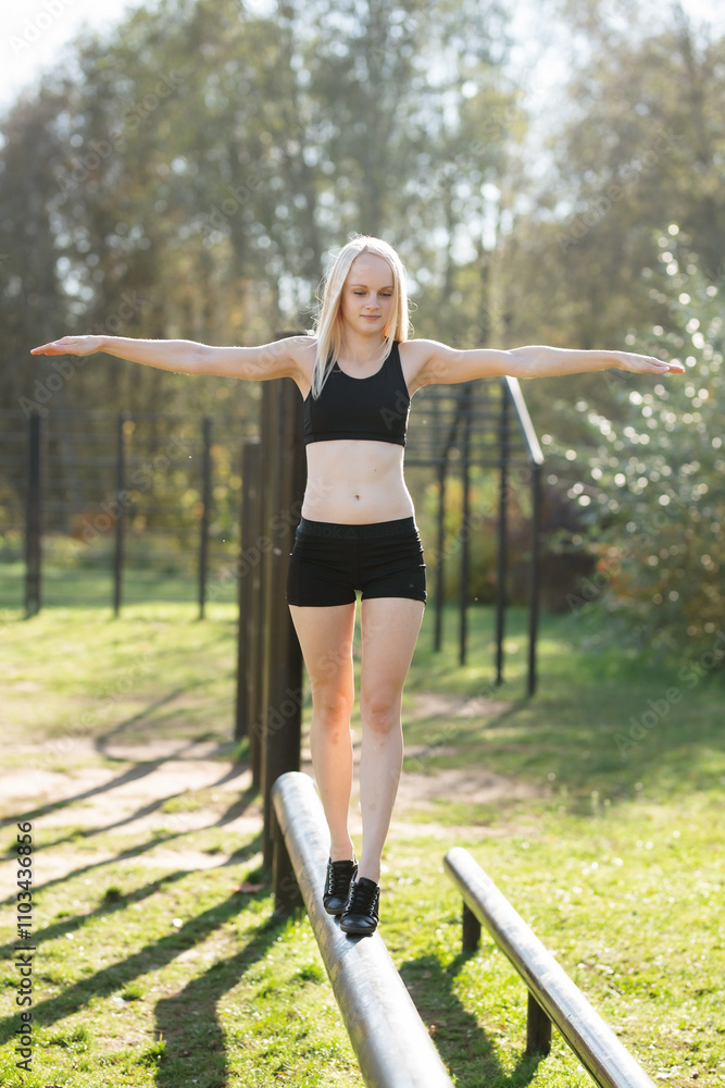 Woman Balancing on Outdoor Beam During Fitness Training Woman Balancing on Outdoor Beam During Fitness Training