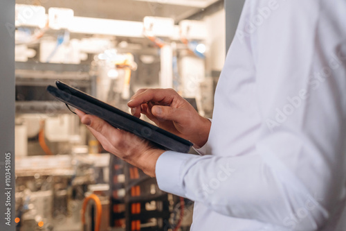 Digital tablet in hands. Close up view of man that is working in the modern factory