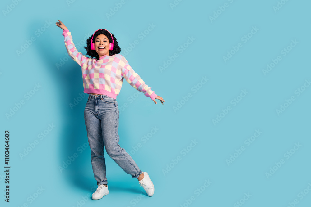 Full size photo of pretty young girl earphones dance discotheque wear trendy pink plaid outfit isolated on blue color background Full size photo of pretty young girl earphones dance discotheque wear trendy pink plaid outfit isolated on blue color background
