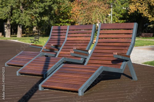 
CITY PARK - Wooden loungers in the recreation area wet with morning dew photo