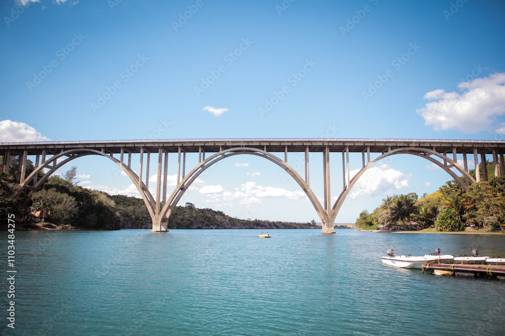 Beautiful arch bridge over clear water in Cuba with lush greenery in the background Beautiful arch bridge over clear water in Cuba with lush greenery in the background