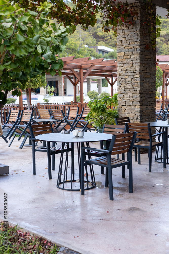 Fototapeta premium Outdoor dining area with empty tables nestled under rustic architecture