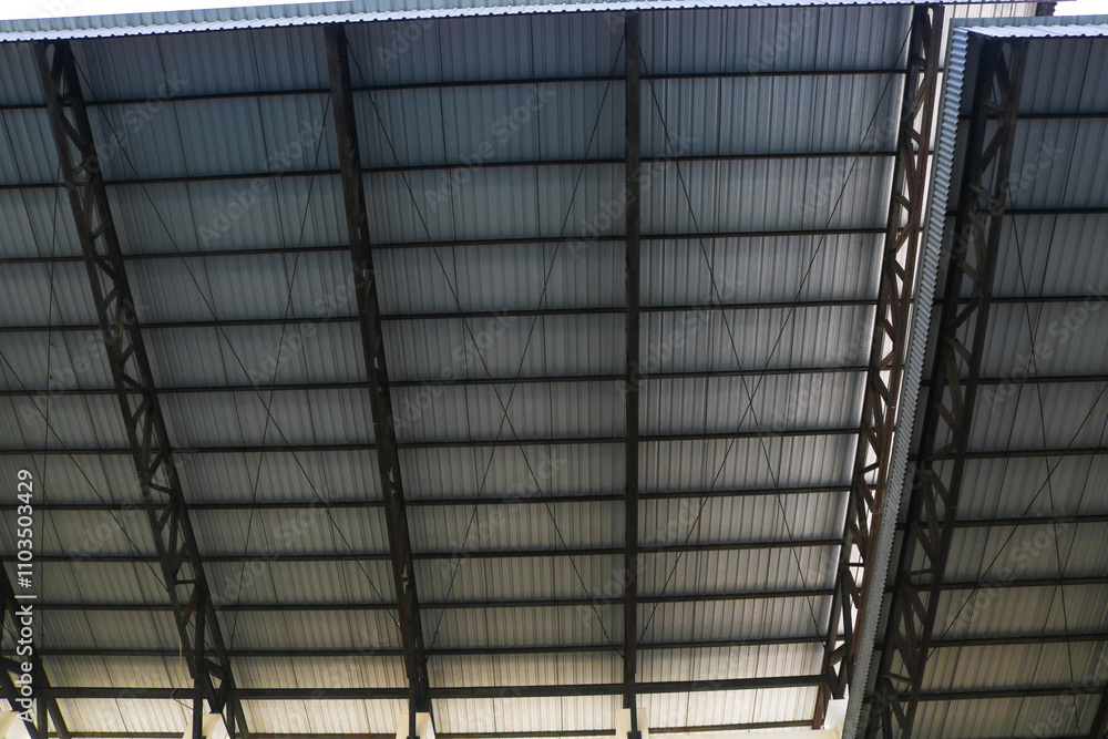 Obraz premium Bottom view of silver corrugated tin roof with steel structure. metal roof. iron tent. Sports stadium roof