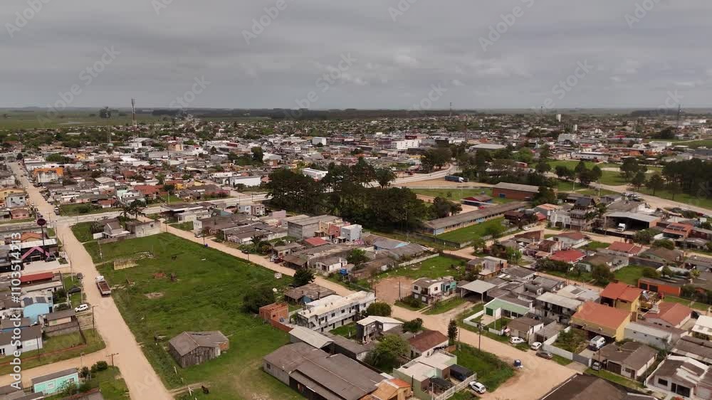 Aerial flyover Brazilian town named Chui with housing area and neighborhood. Cloudy day at border town between Brazil and Uruguay. Street during and homes in district. Wide shot. Aerial flyover Brazilian town named Chui with housing area and neighborhood. Cloudy day at border town between Brazil and Uruguay. Street during and homes in district. Wide shot.