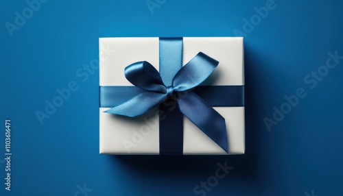 Beautifully wrapped gift box with blue ribbon on a blue background