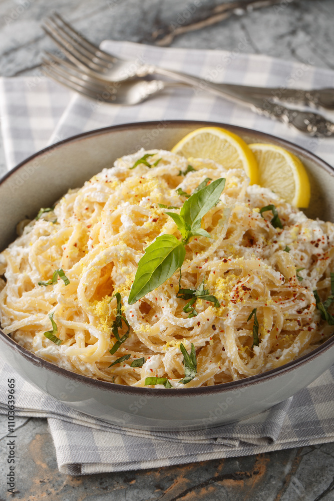 Linguine pasta with lemon zest and ricotta cheese, parmesan close-up in a bowl on the table. Vertical