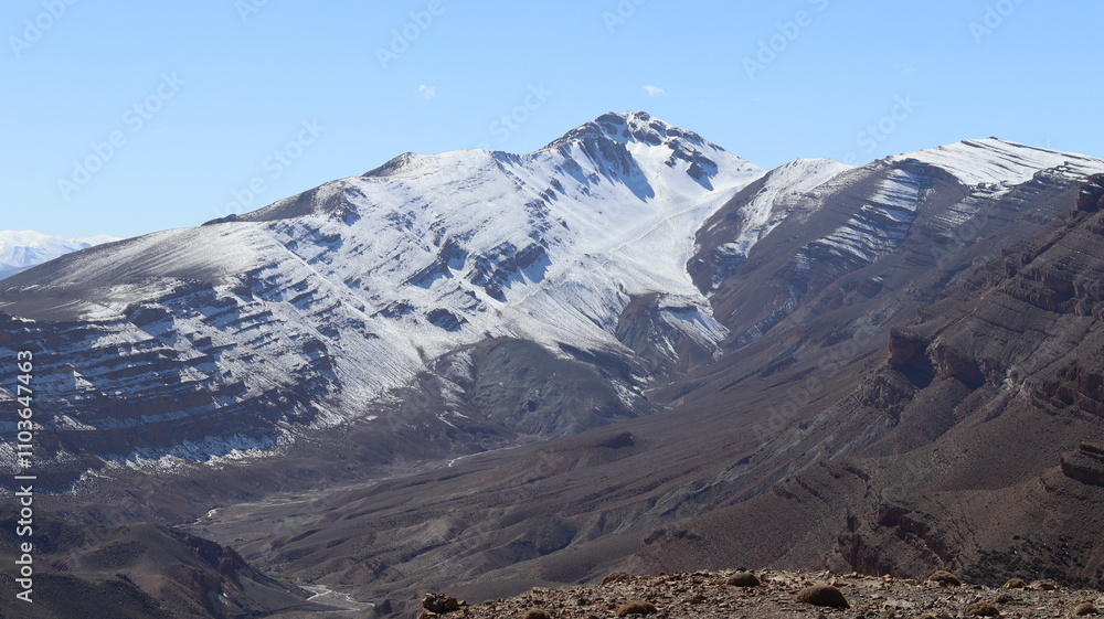 Fototapeta premium Tislit Lake in Imilchil, Morocco's Haut Atlas Oriental National Park, surrounded by snow-capped mountains, rugged terrain, and serene blue waters, perfect for nature, hiking, and scenic photography.