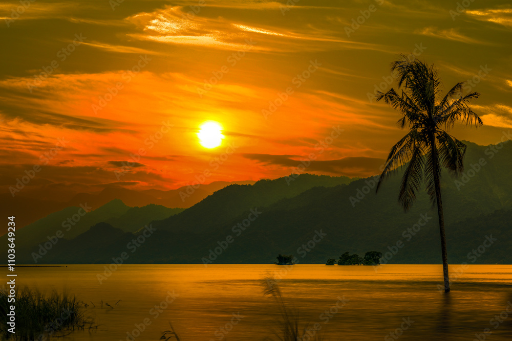 In sunset hour,beautiful mountain scenery silhouette
,colorful sky cloudscape and view of coconut tree in the lake form a scenic scene at Zengwen Reservoir after sunset, Tainan City, Taiwan.