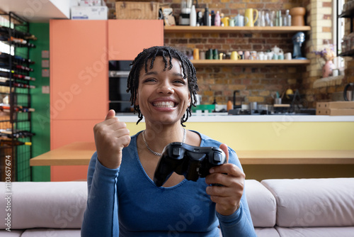 Young adult female playing and winning a video game at home photo