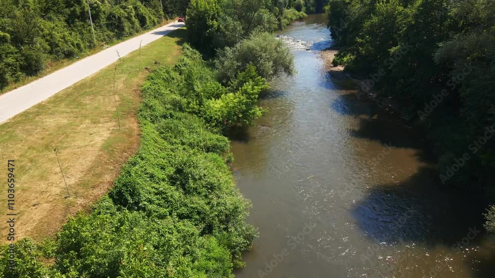 Relaxing river view along a quiet road surrounded by lush greenery near a natural landscape Relaxing river view along a quiet road surrounded by lush greenery near a natural landscape