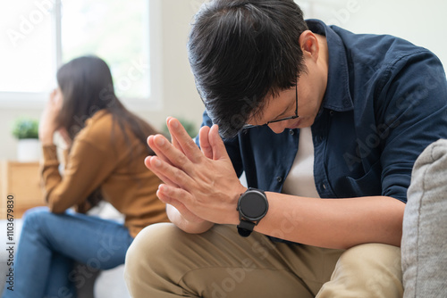 Family problem concept, Close-up hands of Asian wife sitting on sofa and husband sitting back to back in the living room at home have problems in a relationship and have an argument photo