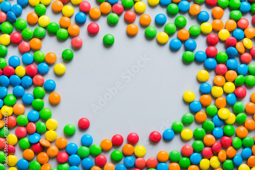 Mixed collection of colorful candy, on colored background. Flat lay, top view. frame of colorful chocolate coated candy photo