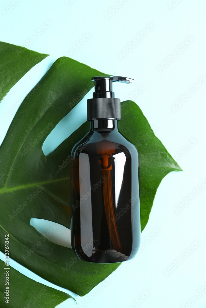Cosmetic bottles with monstera leaf on colored background Cosmetic bottles with monstera leaf on colored background