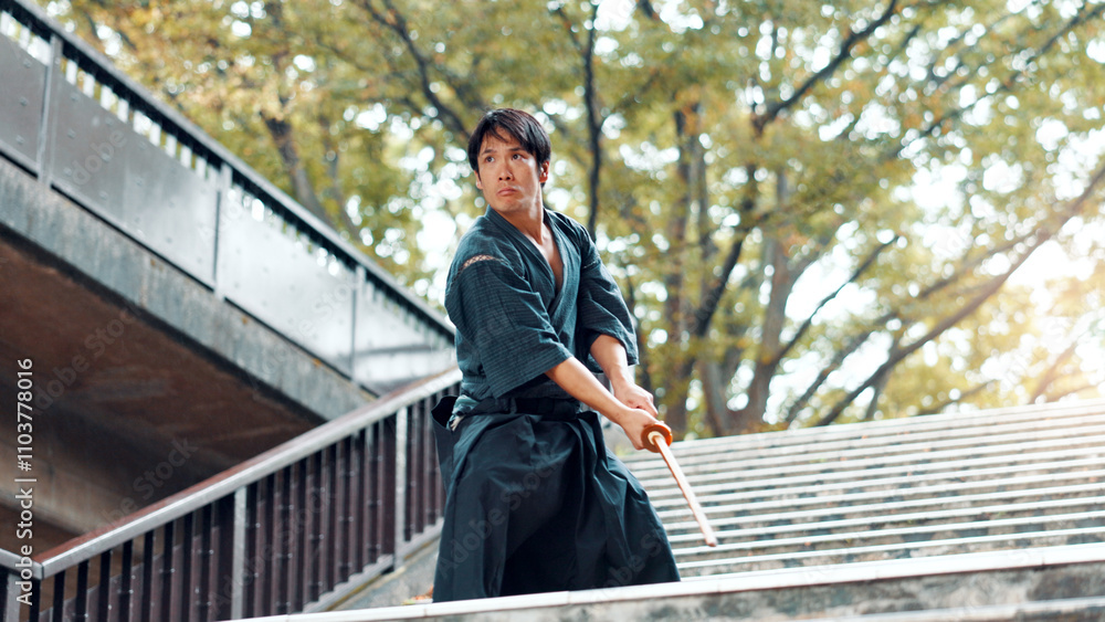 Fototapeta premium City, bamboo sword and Asian man on stairs for martial arts, Kendo practice and exercise. Culture, heritage and person with shinai, bokuto and weapon for skill, fight or traditional training in Japan