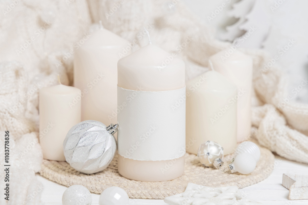 Pillar candle with label near white sweater and wooden Christmas decor, mockup Pillar candle with label near white sweater and wooden Christmas decor, mockup