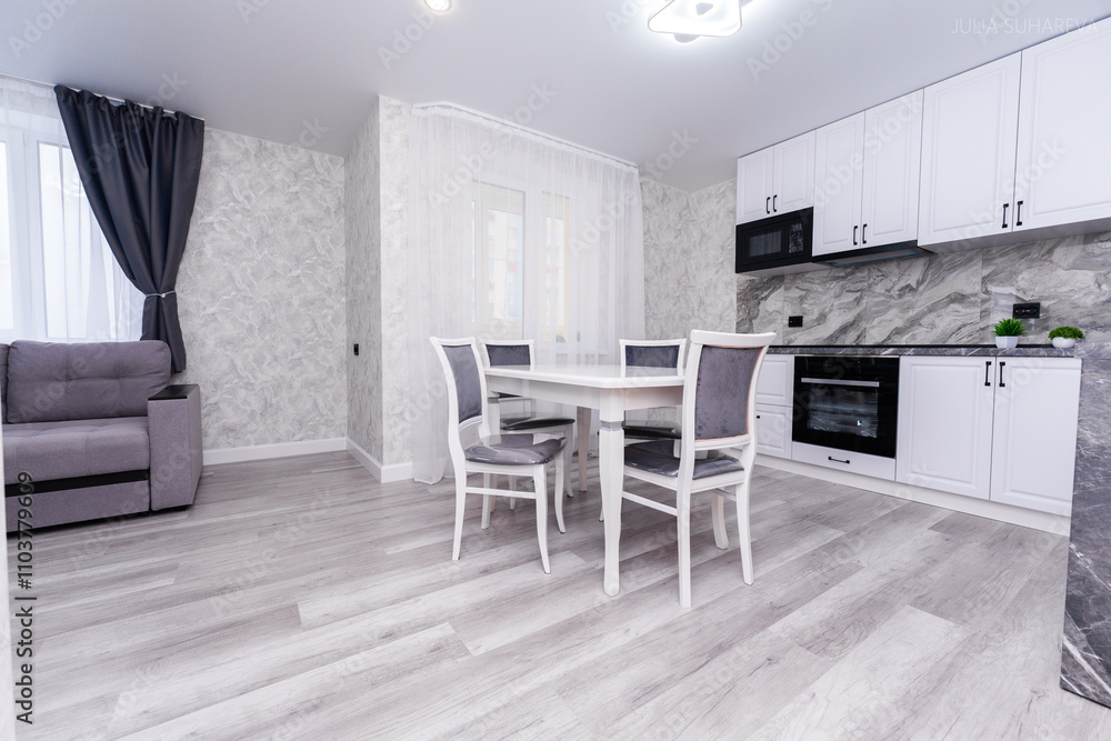 Fototapeta premium modern apartment interior design kitchen and hall. large dining table with chairs. interior in light and gray colors