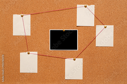 Blank paper notes and an empty photo are pinned to a cork board. The concept of detective investigation.