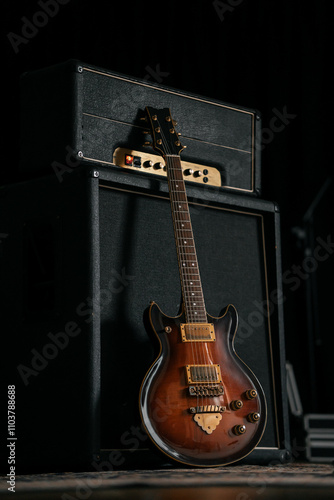Electric guitar leaning against an amplifier and speaker, professional musical instruments