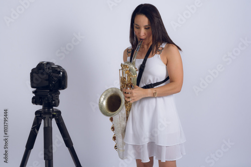 Canvas Print Female saxophonist records herself with a camera making music