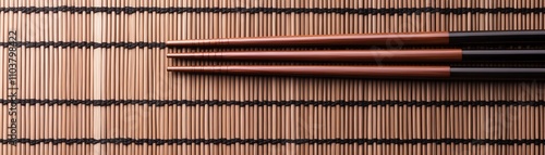 Chopsticks placed on a bamboo mat, elegant dining setup.