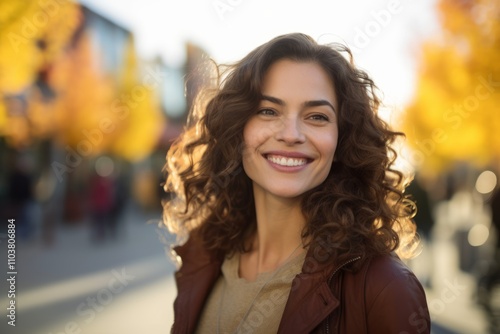 Portrait of beautiful young woman with curly hair in the city.