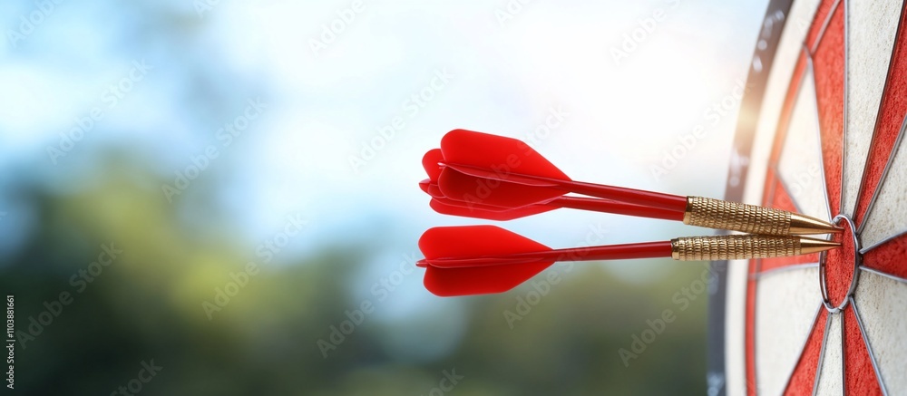 Two red darts hitting the bullseye on a dartboard outdoors. Two red darts hitting the bullseye on a dartboard outdoors.