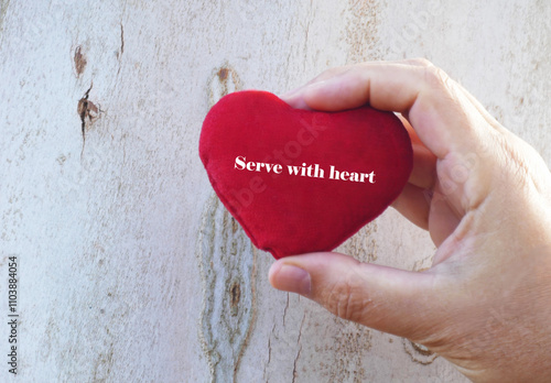 Serve with heart - man hold in hand red heart on white wooden background photo