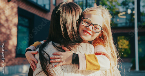 Bild auf Leinwand Camera focus on cute Caucasian girl hugging her mother